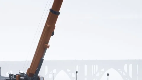 Construction crane works on site near bridge during overcast weather Stock Footage 343532345