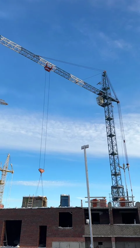 Construction cranes and builders work on the construction site outdoors Stock Footage 301145237