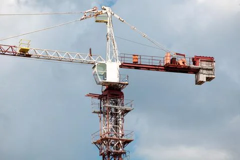 Construction cranes and building on construction site with cloudy blue sky Stock Photos