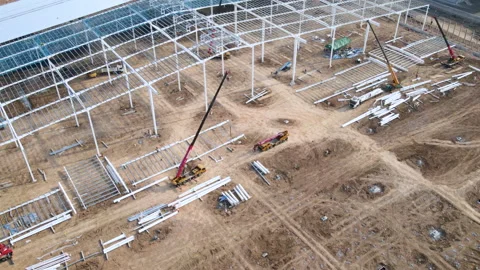 Construction cranes and workers are building large warehouse hyperlapse Stock Footage 171415320