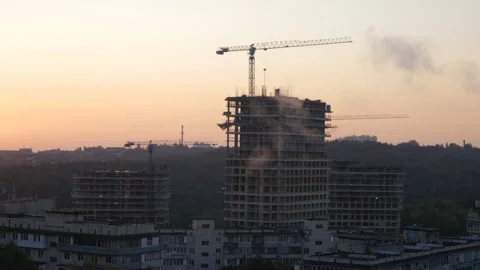 Construction cranes are erecting the walls of new buildings Stock Footage 141613182