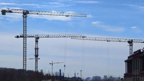Construction cranes on a blue sky background. Industrial tower crane. Stock Footage 306953357