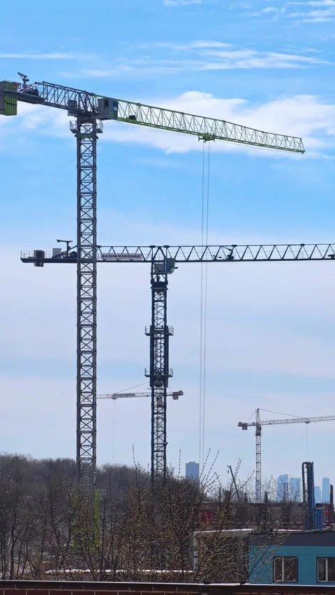 Construction cranes on a blue sky background. Industrial tower crane. Video stock 309883184