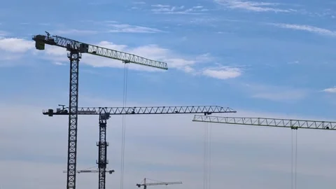 Construction cranes on a blue sky background. Industrial tower crane. Video stock 309928530