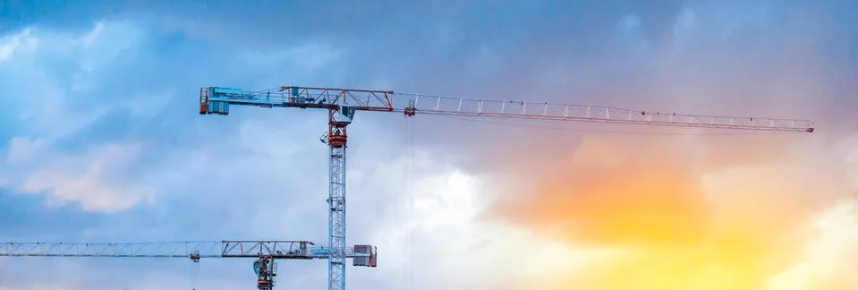 Construction cranes on blue sky background Stock Photos