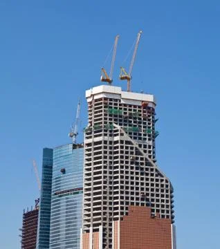 Construction cranes on the construction of office building Stock Photos