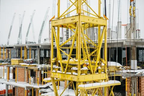 Construction cranes at the construction site of a modern neighborhood in winter Stock Photos