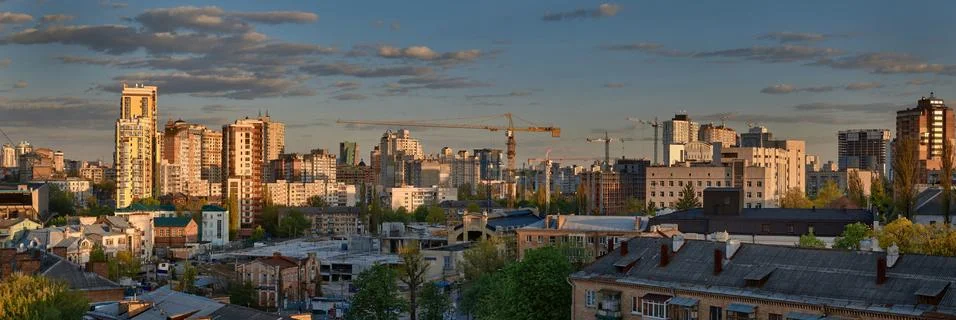 Construction cranes on the evening cityscape background Photos