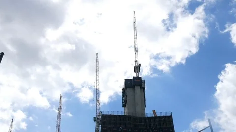 Construction cranes high rise clouds passing time lapse Stock Footage 99425102