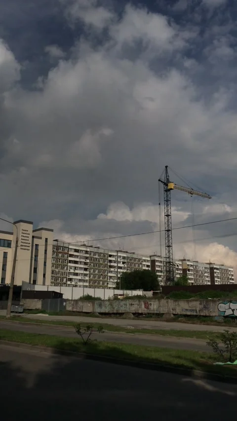 Construction cranes at home against the backdrop of a beautiful cloudy sky road Stock Footage 161559468