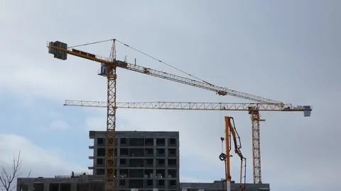 Construction cranes lift materials at a building site in a city during the day Stock Footage 330987631