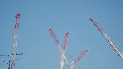 Construction cranes move around on sunny day with blue sky Stock Footage 293705941