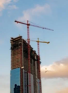 Construction cranes over blue sky background Stock Photos