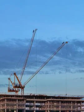Construction cranes over a building under construction Stock Photos