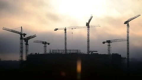 Construction cranes silhouetted against sunset sky Video stock 72264142