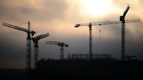 Construction cranes silhouetted against sunset sky Video stock 72264151