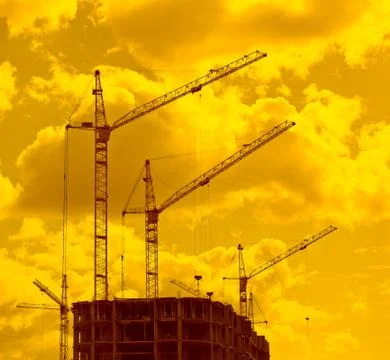 Construction cranes in sunset lights Stock Photos