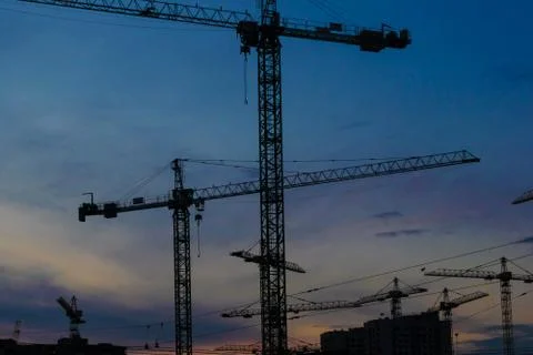 Construction cranes on sunset Stock Photos