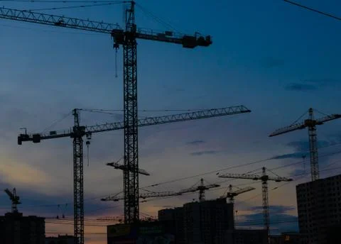 Construction cranes on sunset Stock Photos