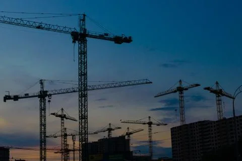 Construction cranes on sunset Stock Photos