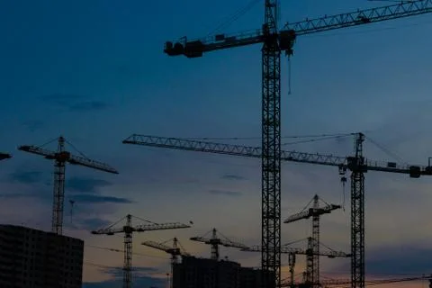 Construction cranes on sunset Stock Photos