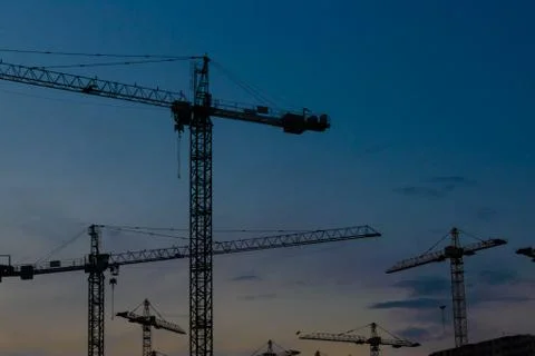 Construction cranes on sunset Stock Photos