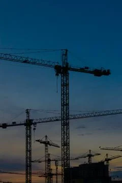 Construction cranes on sunset Stock Photos