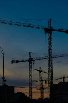 Construction cranes on sunset Stock Photos