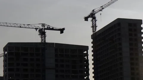 Construction cranes on top of a building under construction. The cranes are Stock Footage 266716384