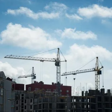 Construction cranes tower above the construction site Stock Photos
