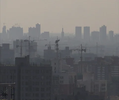 Construction cranes visible over very smoggy skyline Stock Footage 86745084