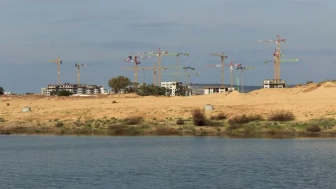 Construction cranes with water pond in foreground timelapse Stock Footage 123875583