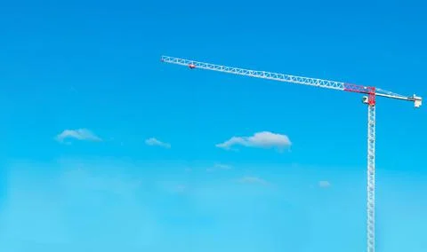 Construction cranes work on creation site against blue sky background. Bottom Stock Photos