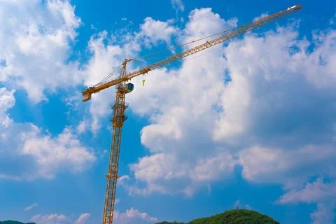 Construction cranes work on creation site against blue sky background. Foto stock