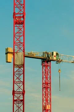 Construction cranes working on a bright day at a building site Stock Photos