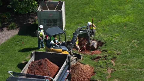 Construction crew digs trench beside Trench Tech shoring box during gas line Stock Footage 345323676
