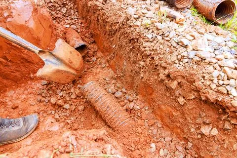 Construction crew digs trench for drainage pipe installation near residenti.. Stock Photos