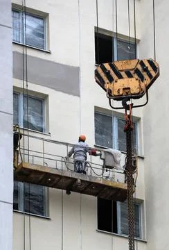 A construction crew diligently attends to the facade of a multi-story buildin Foto stock