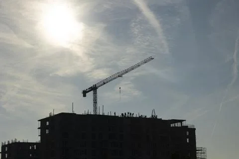 Construction crew installs metal components on rising concrete tower Stock Photos