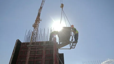 Construction crew positions a crane suspended concrete hopper above formwork 库存影片 340030680