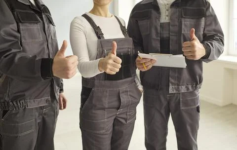 Construction crew thumbs up closeup with clipboard affirming quality service Stock Photos