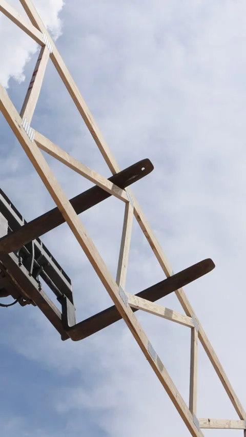 Construction crew uses equipment to lift wooden beams for building structure Stock Footage 313827329