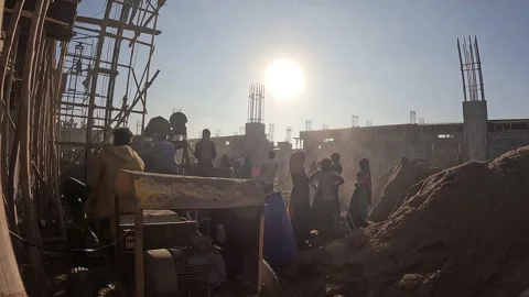 Construction Crew Working Around Concrete Mixer at Building Site Under Bright Stock Footage 337789978