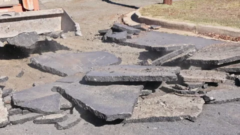 Construction crew working on road repair using heavy machinery in daytime Stock Footage 339011262