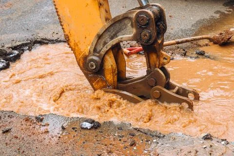 Construction crew works on water main break in street city Stock Photos