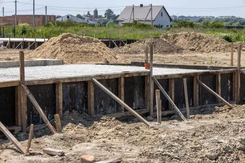 Construction crews lay a cement slab as part of foundation work for a new h.. 库存照片