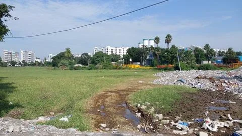 Construction Debris Dumped on Green Field Near Apartments Stock Photos