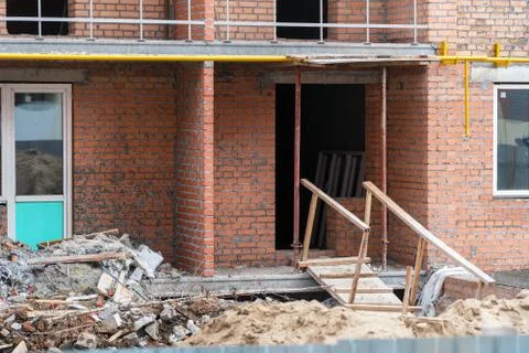 Construction debris next to a red brick house under construction Foto stock