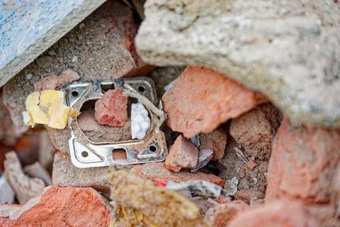 Construction debris pile with broken bricks stones and a outlet ring. Stock Photos
