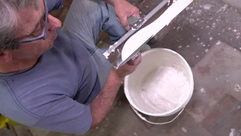Construction Detail: Mixing Compound with Spatula and Bucket Stock Footage 323872308